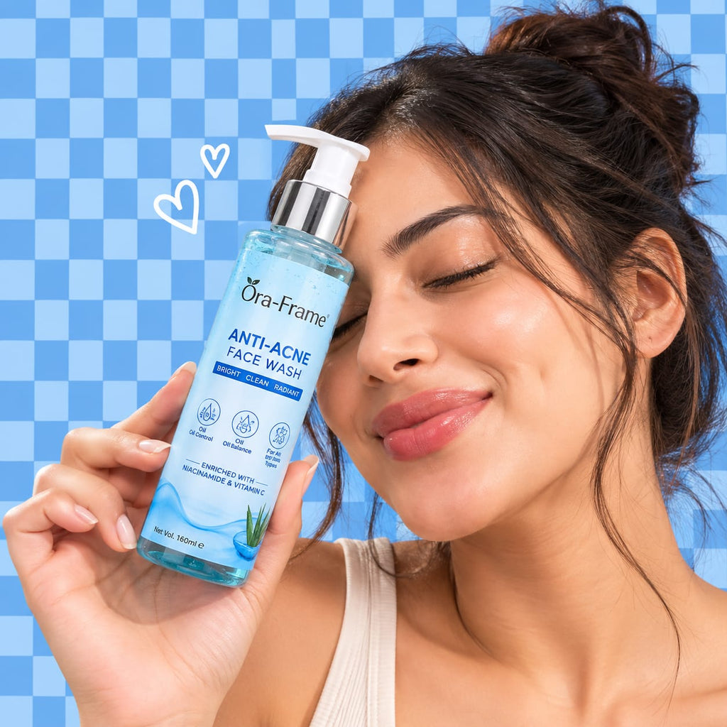 A woman holding a bottle of Ora-Frame Anti-Acne Face Wash against a blue checkered background.